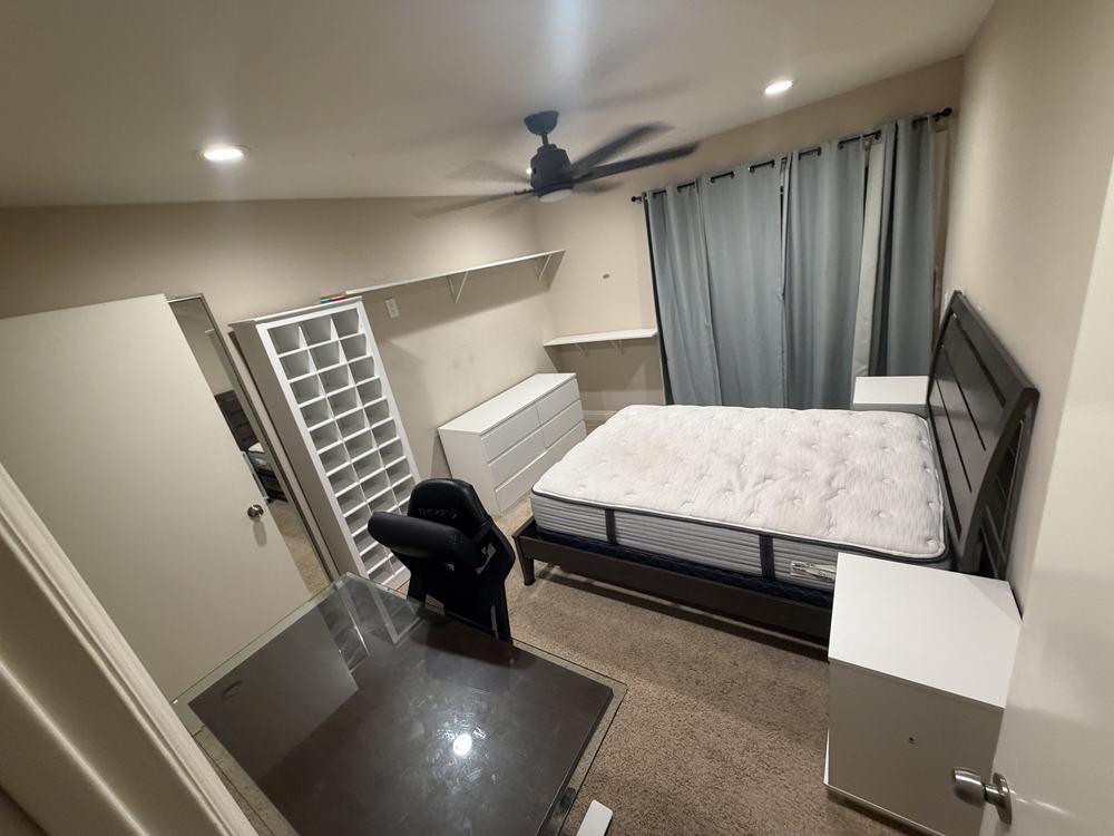 Bedroom with a bed, dressers, shoe cubby, desk and chair before removal