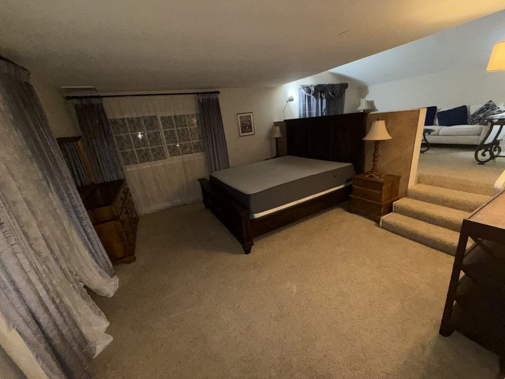 Loft bedroom with a bed, nightstands, dresser and lamps before removal