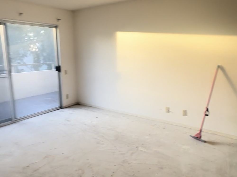 The same living room swept to the bare slab after our team hauled the debris